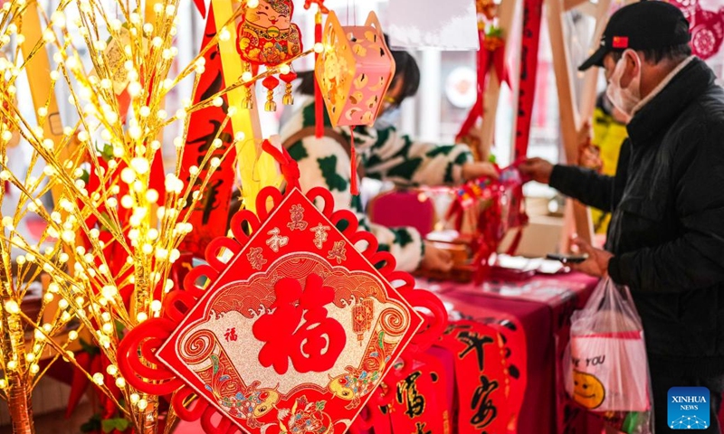 A resident selects decorations for the upcoming Spring Festival at Lanhua Square in Nanming District of Guiyang City, southwest China's Guizhou Province, Jan. 14, 2023. (Xinhua/Tao Liang)