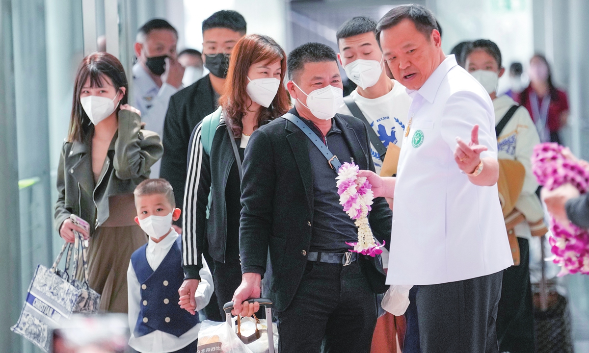 Thailand's Public Health Minister Anutin Charnvirakul (right) hands garlands to Chinese tourists on their arrival at Suvarnabhumi International Airport in Samut Prakarn province, Thailand on January 9, 2023. Thailand is looking forward to hosting large numbers of visitors from China again after it downgraded its COVID-19 prevention and control measures and eased travel restrictions. Photo: VCG
