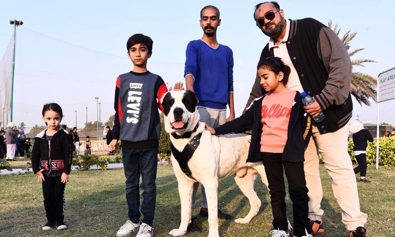 People pose for a photo with a dog during a dog show in southern Pakistani port city of Karachi on Jan. 8, 2023. Photo: Xinhua