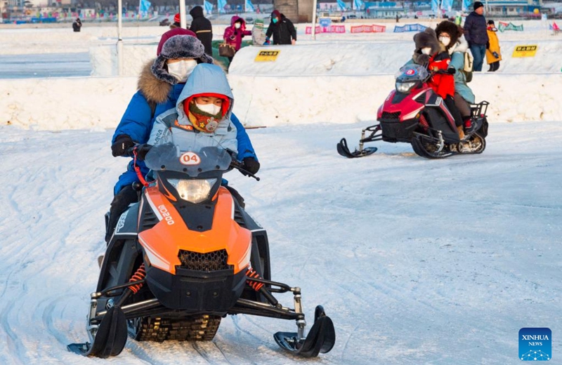 People have fun at the Ice and Snow Carnival park on the Songhua River in Harbin, northeast China's Heilongjiang Province, Jan. 14, 2023. Harbin is famous for its rich ice and snow resources. This winter, the city opened three ice and snow-themed parks, launched 12 ice and snow experience products and 10 such tourism routes, and created more than 100 related activities to promote the development of winter tourism, culture, fashion and sports. (Xinhua/Xie Jianfei)