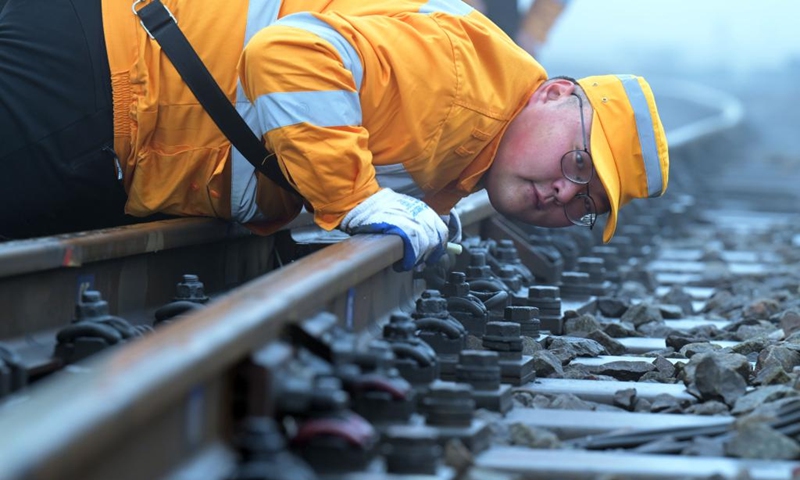 A worker carries out a maintenance task along a railway section at Hefei East Railway Station in Hefei, east China's Anhui Province, Jan. 13, 2023. The maintenance team under the Hefei branch of China Railway Shanghai Group Co., Ltd has been busy performing maintenance tasks in non-service hours to make sure that safe and smooth train rides are available to passengers during the Spring Festival travel rush. (Xinhua/Zhou Mu)