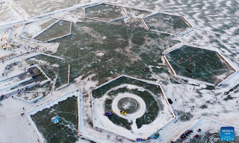 This aerial photo taken on Jan. 14, 2023 shows tourists playing at the Ice and Snow Carnival park on the Songhua River in Harbin, northeast China's Heilongjiang Province. Harbin is famous for its rich ice and snow resources. This winter, the city opened three ice and snow-themed parks, launched 12 ice and snow experience products and 10 such tourism routes, and created more than 100 related activities to promote the development of winter tourism, culture, fashion and sports. (Xinhua/Xie Jianfei)