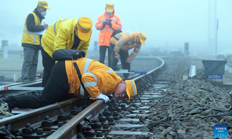 Workers carry out a maintenance task along a railway section at Hefei East Railway Station in Hefei, east China's Anhui Province, Jan. 13, 2023. The maintenance team under the Hefei branch of China Railway Shanghai Group Co., Ltd has been busy performing maintenance tasks in non-service hours to make sure that safe and smooth train rides are available to passengers during the Spring Festival travel rush. (Xinhua/Zhou Mu)