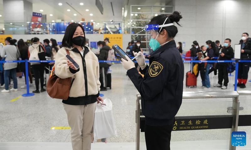 A staff member of the customs of Shanghai Pudong International Airport checks the information of an inbound passenger in east China's Shanghai, Jan. 8, 2023. From Sunday, China starts managing COVID-19 with measures designed for combating Class B infectious diseases, instead of Class A infectious diseases. (Xinhua/Ding Ting)