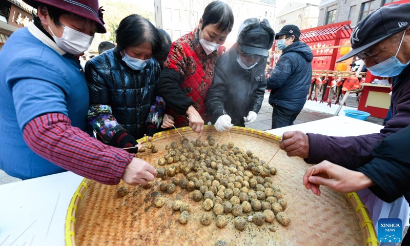 People try local snacks at a shopping festival in Pingyao Town of Yuhang District in Hangzhou City, east China's Zhejiang Province, Jan. 11, 2023. The shopping festival featuring local agricultural and cultural products kicked off here on Wednesday to warm up for the upcoming Chinese Lunar New Year.(Photo: Xinhua)
