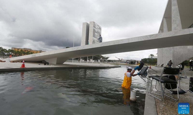 Workers clear damaged furniture outside Planalto Palace, the presidential headquarters, in Brasilia, Brazil, Jan. 9, 2023. Brazil's three branches of government issued a joint statement on Monday, expressing unity and calling on society to remain calm in defense of peace and democracy.(Photo: Xinhua)