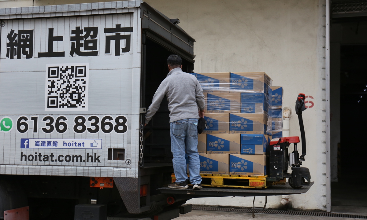A worker unloads boxes of goods from a truck in Hong Kong on January 12, 2023, as local business gears up to resume exchanges with mainland after borders were reopened on January 8. Photo: Zhao Yusha/Global Times