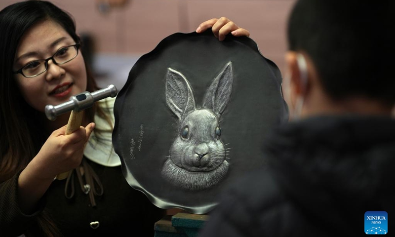 An artist displays a rabbit-themed relief to visitors at a cultural studio in Xinhua District of Shijiazhuang, north China's Hebei Province, Jan. 12, 2023. Cultural activities promoting intangible cultural heritages were held in Xinhua District to greet the upcoming Chinese Lunar New Year.(Photo: Xinhua)