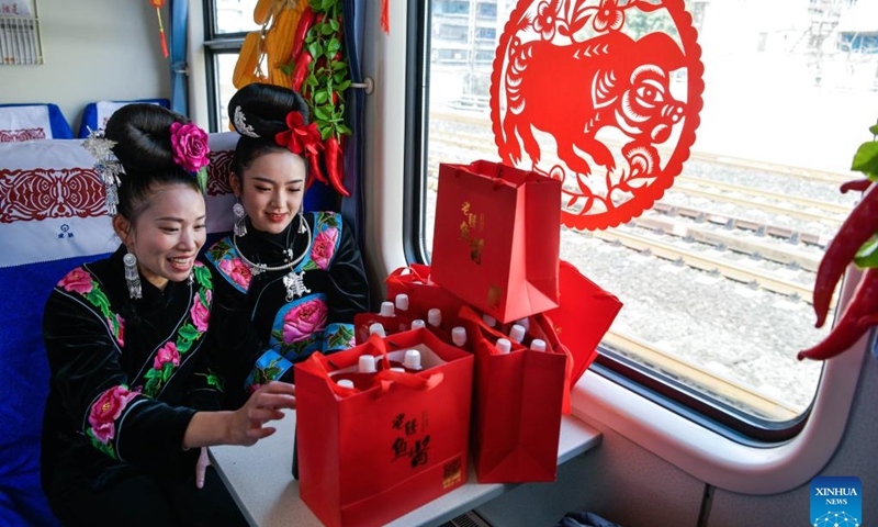 Passengers sit beside the products they bought on train No. 5640 in southwest China's Guizhou Province, Jan. 10, 2023. The pair of slow trains No. 5640 and No. 5639 run in Guizhou Province between Yuping Dong Autonomous County of Tongren City and Guizhou's capital Guiyang City. The trains pass through several townships in Qiandongnan Miao and Dong Autonomous Prefecture, connecting more than 100 ethnic minority villages along the 337-km route.(Photo: Xinhua)