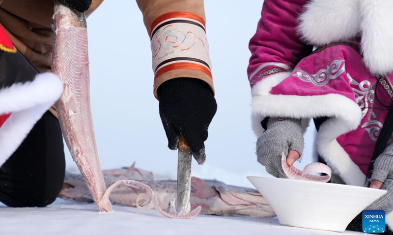 Hezhe people slice up frozen fish on the East Lake of Fuyuan City, northeast China's Heilongjiang Province, Jan. 11, 2023. The Hezhes, one of the smallest ethnic minority groups in China, hold various activities to welcome the upcoming Chinese Lunar New Year.(Photo: Xinhua)