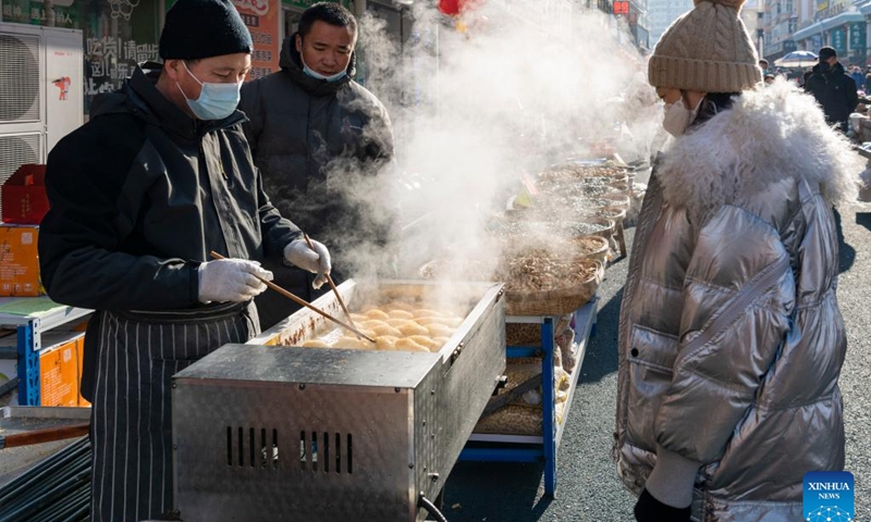 Local residents buy fried dough twist (or Mahua), a traditional Chinese snack, at an open air market for Spring Festival goods in Suifenhe, northeast China's Heilongjiang Province, Jan. 12, 2023. As the Chinese Lunar New Year approaches, many citizens in Suifenhe flocked to local markets to make special purchases for the upcoming Spring Festival.(Photo: Xinhua)