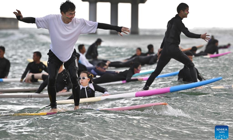 Tourists go surfing at Riyue Bay in Wanning, south China's Hainan Province, Jan. 13, 2023. Surfing has become a symbol of Wanning thanks to its unique geographical and climatic advantages. (Xinhua/Guo Cheng)