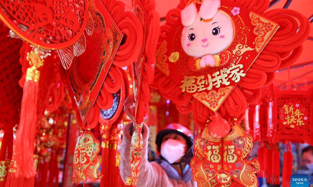 A citizen shops for decorative items for the upcoming Chinese Lunar New Year at a shop in Longhui County of Shaoyang City, central China's Hunan Province, Jan. 16, 2023. As the Chinese Lunar New Year of the Rabbit approaches, decorative items and handicraft works featuring the image of the rabbit, one of the 12 Chinese Zodiac animals, are sweeping the streets, adding festive atmosphere to the event. (Photo by Zeng Yong/Xinhua)