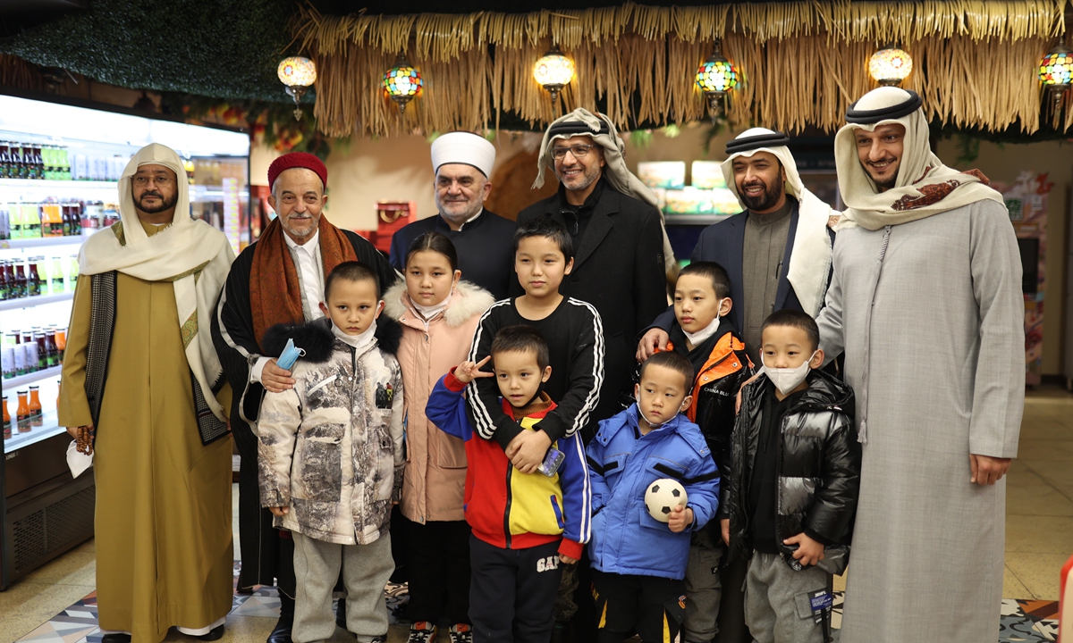 Members of a delegation consisting of more than 30 Islamic figures and scholars from 14 countries, including the UAE, Saudi Arabia and Egypt, visit a Urumqi bazaar and take photos with local residents during their trip to China's Xinjiang Uygur Autonomous Region on January 8. Photo: Liu Xin/GT