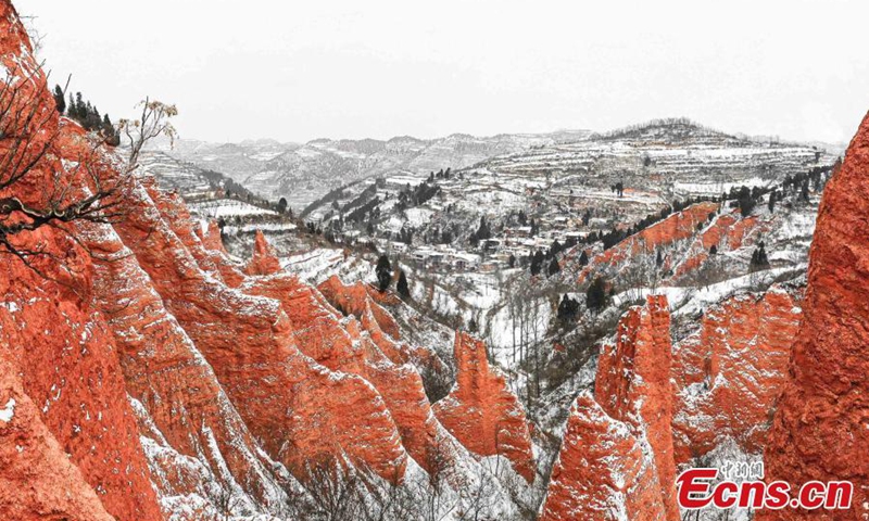 2023 年 1 月 15 日，中国中部河南省卢氏县庙沟村的红石谷风景区遭遇大雪，为其丹霞地貌增添了色彩，其特点是红色砂岩特征。  （摄影：中新社/牛金峰）