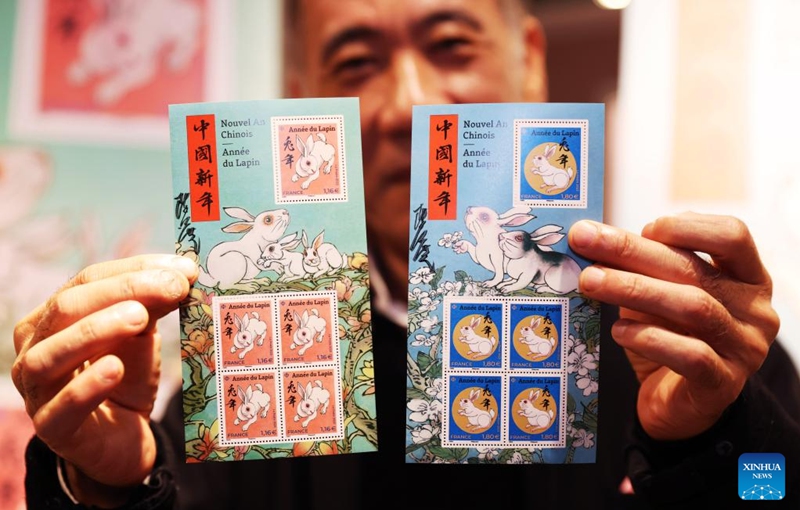 Chinese artist Chen Jianghong displays the Year of the Rabbit commemorative stamps designed by him during a launching ceremony in Paris, France, Jan. 14, 2023. (Xinhua/Gao Jing)