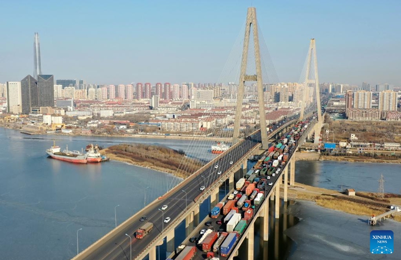 This aerial photo taken on Jan. 10, 2023 shows the Haihe River bridge, an important channel of freight transport, in Binhai New Area of North China's Tianjin. People's social and economic activities gradually return to normal after China's optimization of its COVID-19 response measures. (Xinhua/Zhao Zishuo)

