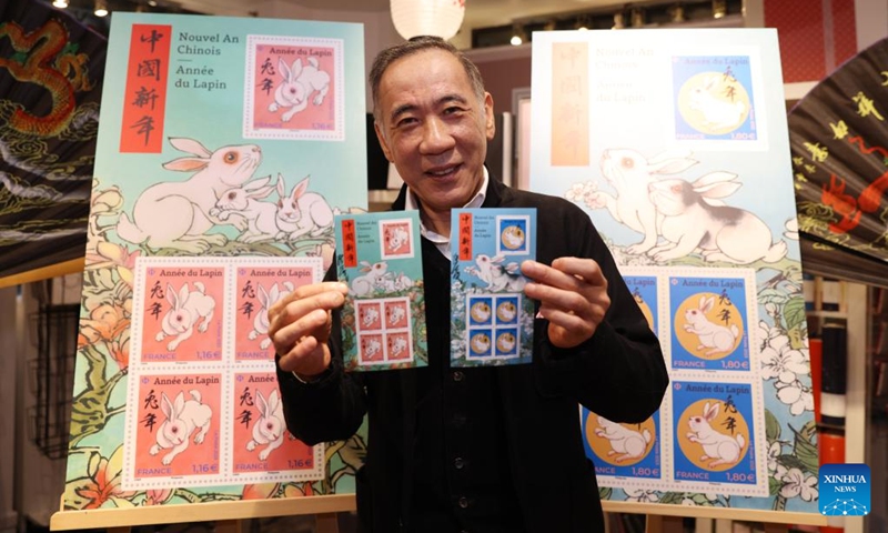 Chinese artist Chen Jianghong displays the Year of the Rabbit commemorative stamps designed by him during a launching ceremony in Paris, France, Jan. 14, 2023. (Xinhua/Gao Jing)