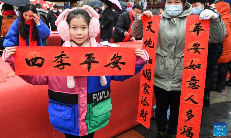 A woman and her daughter display a Spring Festival couplet they received at a couplets writing activity in Yongchuan District, southwest China's Chongqing, Jan. 16, 2023.(Photo: Xinhua)