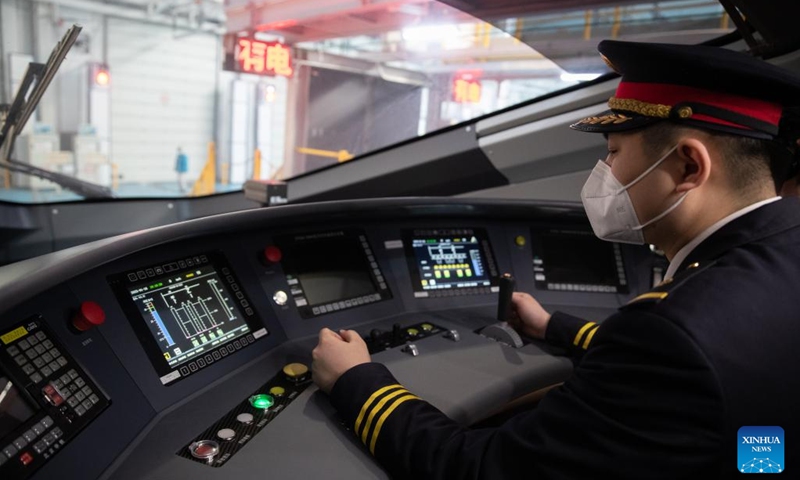 A staff member tests and adjusts equipment in the cockpit of the Fuxing Electric Multiple Unit (EMU) CR400BF-GZ, northeast China's Heilongjiang Province, Jan. 16, 2023. The most frost-resistant and most intelligent member of China's Fuxing bullet train family, the Fuxing EMU CR400BF-GZ, settled on Monday in northeast China's Heilongjiang Province.(Photo: Xinhua)