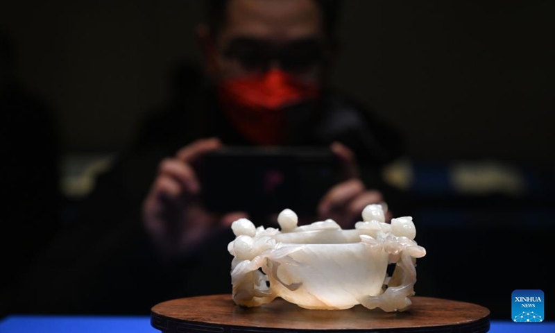 A visitor takes photo of a jade carving artwork at the Palace Museum in Beijing, capital of China, Jan. 16, 2023. A Joint Exhibition on Jinshi Culture and Arts Through the Ages, featuring Chinese ancient imperial scholars, kicked off at the Wumen Exhibition Hall of the Palace Museum. Some 179 selected artworks since the Tang Dynasty (618-907) were on display.(Photo: Xinhua)