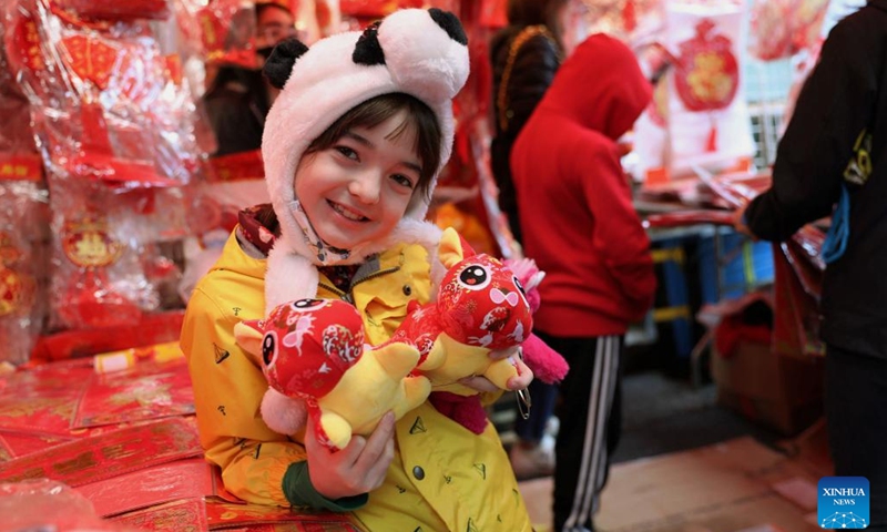 A young girl holds two stuffed toys at a fair in celebration of the upcoming Chinese Lunar New Year in Chinatown, San Francisco, the United States, Jan. 15, 2023.(Photo: Xinhua)