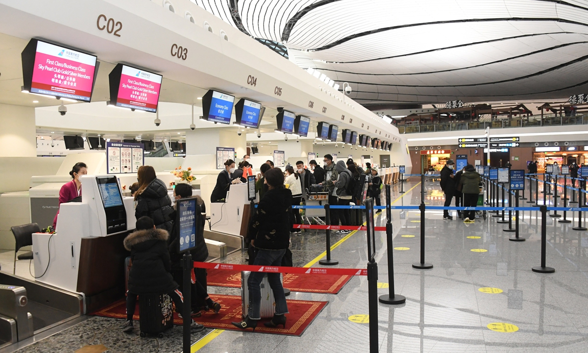 Passengers check in for flight CZ309 from Beijing to Hong Kong at Beijing Daxing International Airport in Beijing on January 17, 2023. The flight marks the resumption of international and regional passenger flight services at the airport after a nearly three-year pandemic-induced suspension (see story on page 11). Photo: Xinhua