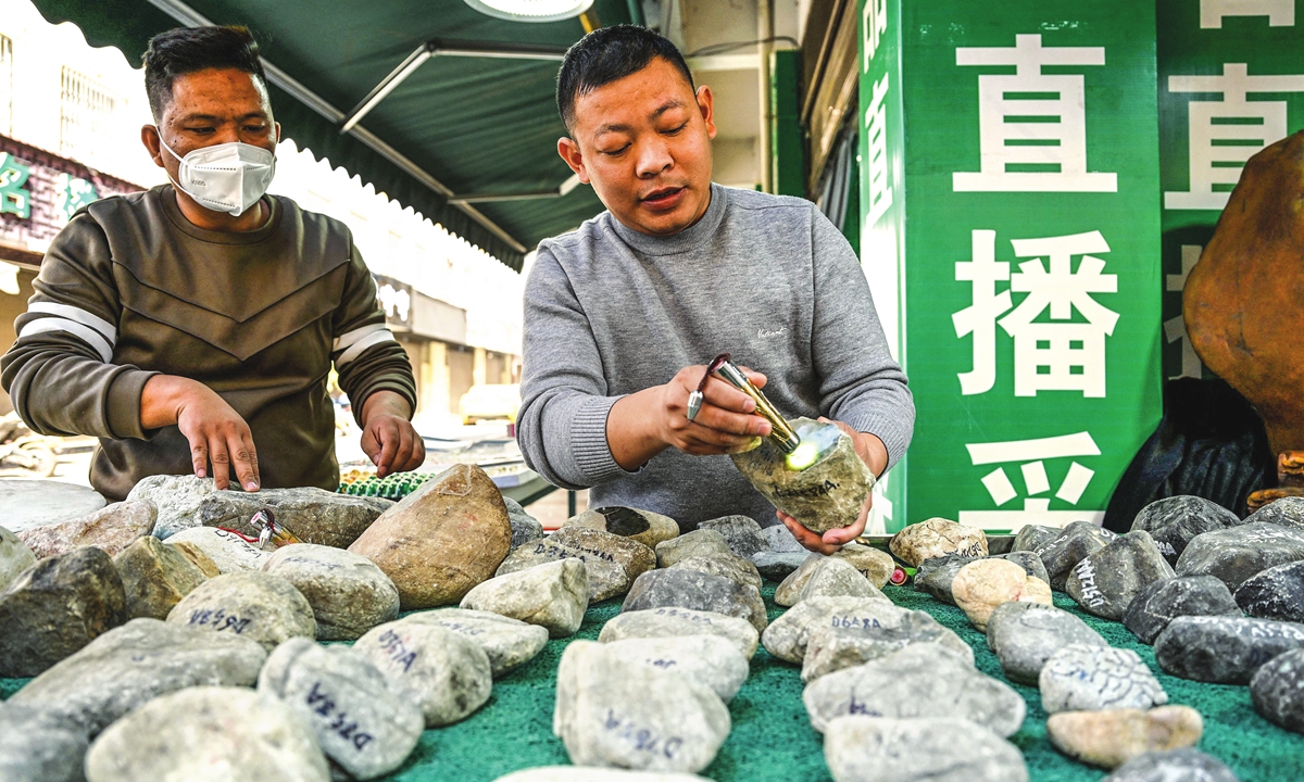 A man shows a raw jade stone at a shop in Ruili, Yunnan Province, on January 13, 2023. Photo: VCG