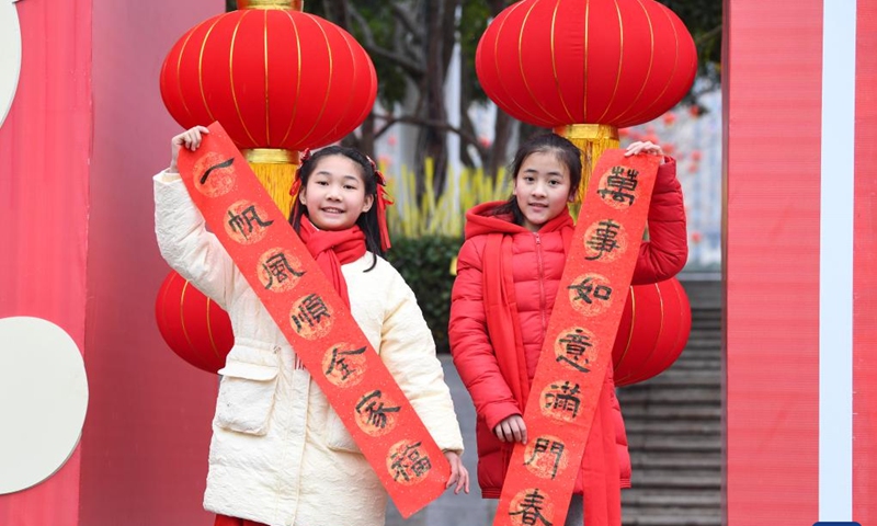 Two girls display a Spring Festival couplet at a couplets writing activity in Yongchuan District, southwest China's Chongqing, Jan. 16, 2023.(Photo: Xinhua)