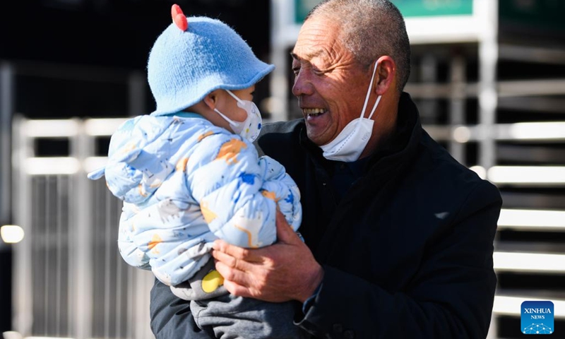 A man holds his grandson in arms after going out of Hohhot East Railway Station in Hohhot, north China's Inner Mongolia Autonomous Region, Jan. 15, 2023. China's Spring Festival travel rush kicked off on Jan. 7 this year and Chinese people are on their way to have a reunion with their loved ones.(Photo: Xinhua)