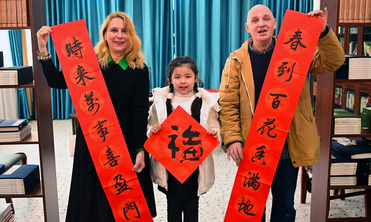 A French couple displays Spring Festival couplets, or <em>chunlian</em>, in an academy of classical learning in Yichun, East China's Jiangxi Province, on January 18, 2023. Pasting <em>chunlian</em> is a Chinese tradition to celebrate the Spring Festival. Photo: VCG