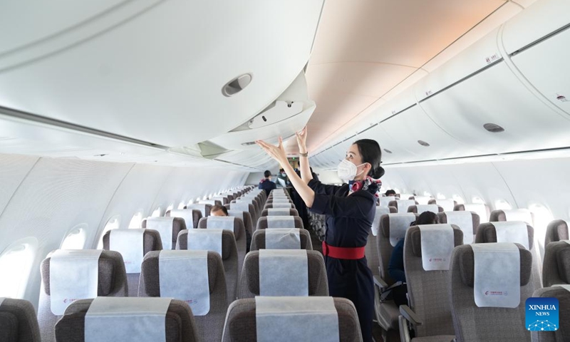 A flight attendant of China Eastern Airlines works in the cabin of a C919 large passenger aircraft, China's first homegrown large jetliner, during a validation flight from Hongqiao International Airport in east China's Shanghai to Capital International Airport in China's capital Beijing, Jan. 9, 2023. The world's first C919 aircraft began its 100-hour aircraft validation flight process on Dec. 26, 2022 after it was delivered to China Eastern Airlines on Dec. 9, 2022.(Photo: Xinhua)