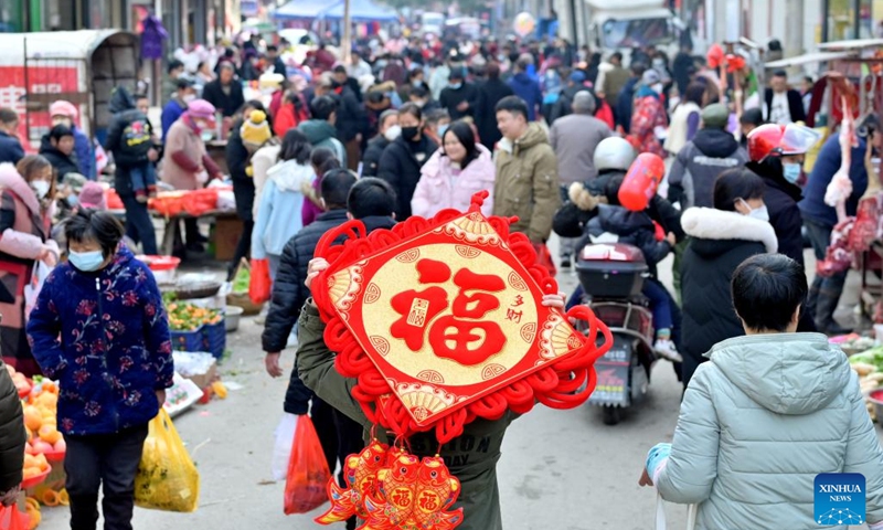 A villager carrying a festive decoration on the back is pictured in a market in Jingzi Town of Shuangfeng County, central China's Hunan Province, Jan. 18, 2023. This year's Spring Festival, or the Chinese New Year, falls on Jan. 22.(Photo: Xinhua)