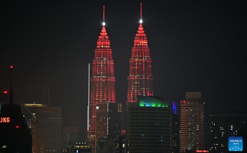 The Petronas Twin Towers are illuminated in red in celebration of the Chinese New Year in Kuala Lumpur, Malaysia, Jan. 21, 2023. (Photo by Chong Voon Chung/Xinhua)