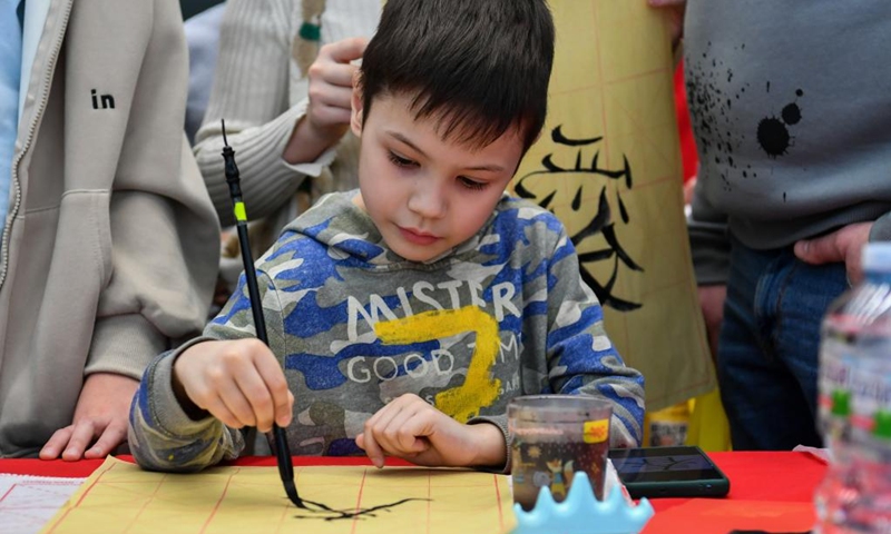 A boy learns calligraphy during a Chinese culture experience activity celebrating the Chinese New Year in Moscow, Russia, Jan. 21, 2023. (Xinhua/Cao Yang)