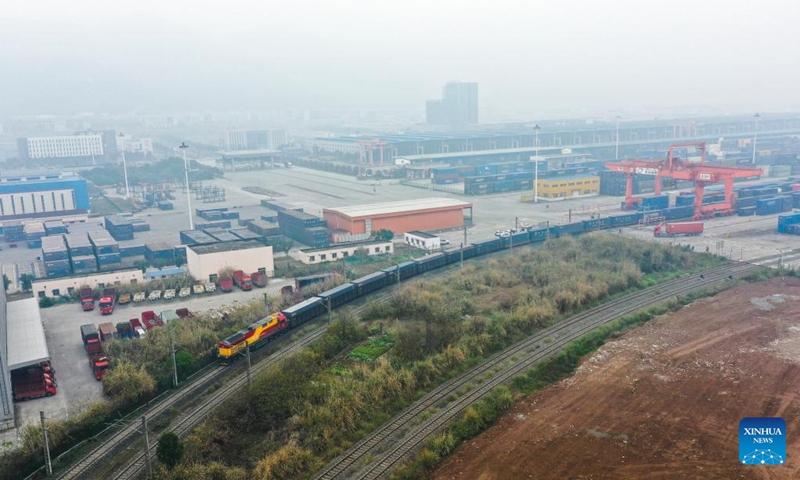 This aerial photo shows a rail-sea intermodal freight train carrying containers of goods, including cars, motorcycles, engines, and sodium carbonate, departing from Tuanjie Village Central Station in southwest China's Chongqing, Jan. 22, 2023. It was the city's first outbound cargo train of the New International Land-Sea Trade Corridor in the Year of the Rabbit. Goods on the train will be transported to Qinzhou port on the country's southern coast, from where they will be shipped to Indonesia, the Philippines, Australia, and some other countries and regions. (Xinhua/Liu Chan)