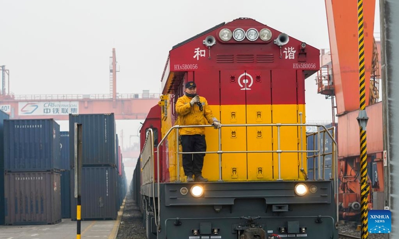 A rail-sea intermodal freight train carrying containers of goods, including cars, motorcycles, engines, and sodium carbonate, waits for departure at Tuanjie Village Central Station in southwest China's Chongqing, Jan. 22, 2023. It was the city's first outbound cargo train of the New International Land-Sea Trade Corridor in the Year of the Rabbit. Goods on the train will be transported to Qinzhou port on the country's southern coast, from where they will be shipped to Indonesia, the Philippines, Australia, and some other countries and regions. (Xinhua/Liu Chan)