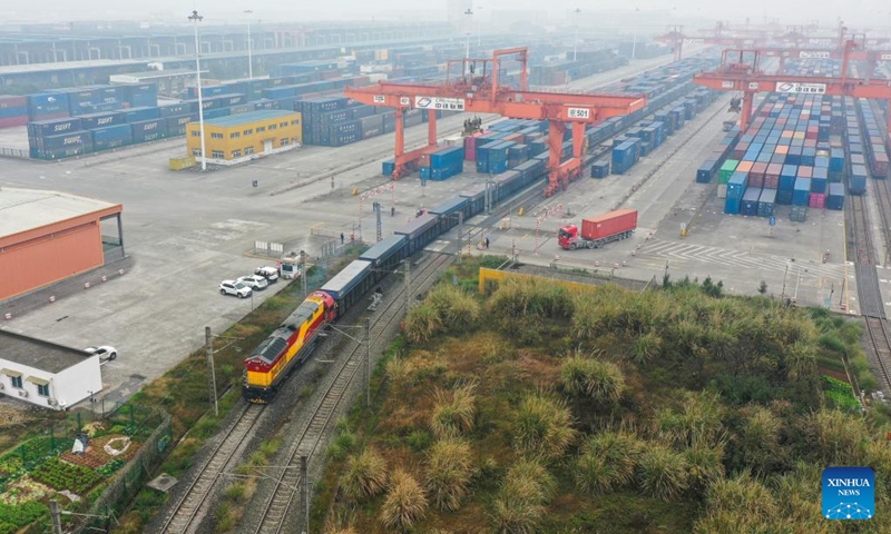 This aerial photo shows a rail-sea intermodal freight train carrying containers of goods, including cars, motorcycles, engines, and sodium carbonate, departing from Tuanjie Village Central Station in southwest China's Chongqing, Jan. 22, 2023. It was the city's first outbound cargo train of the New International Land-Sea Trade Corridor in the Year of the Rabbit. Goods on the train will be transported to Qinzhou port on the country's southern coast, from where they will be shipped to Indonesia, the Philippines, Australia, and some other countries and regions. (Xinhua/Liu Chan)