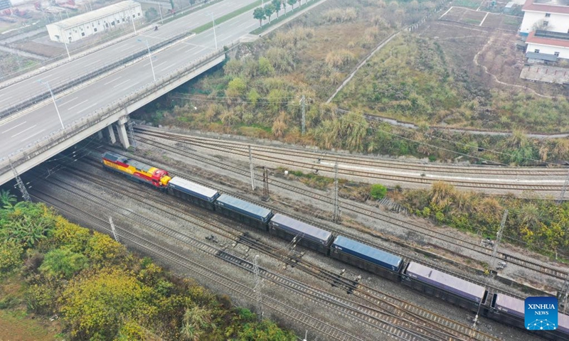 This aerial photo shows a rail-sea intermodal freight train carrying containers of goods, including cars, motorcycles, engines, and sodium carbonate, departing from Tuanjie Village Central Station in southwest China's Chongqing, Jan. 22, 2023. It was the city's first outbound cargo train of the New International Land-Sea Trade Corridor in the Year of the Rabbit. Goods on the train will be transported to Qinzhou port on the country's southern coast, from where they will be shipped to Indonesia, the Philippines, Australia, and some other countries and regions. (Xinhua/Liu Chan)