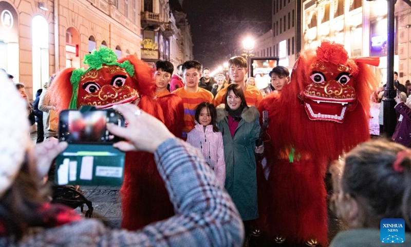 People pose for photos with lion dance performers during an event celebrating the Chinese Lunar New Year in Belgrade, Serbia, Jan. 21, 2023. (Photo by Wang Wei/Xinhua)