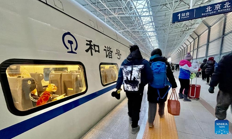 Passengers take a train at Beijing North Railway Station in Beijing, capital of China, Jan. 24, 2023. The Beijing-Zhangjiakou high-speed railway line brings great convenience to people's skiing trip to Chongli district of Zhangjiakou City in north China's Hebei province. (Xinhua/Li Xin)