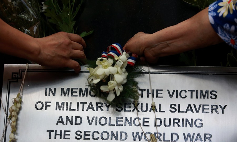 People present flowers to a newly unveiled historical marker titled In Memory of the Victims of Military Sexual Slavery and Violence During the Second World War in Paranaque City in Metro Manila, the Philippines on Aug. 25, 2019.(Photo: Xinhua)