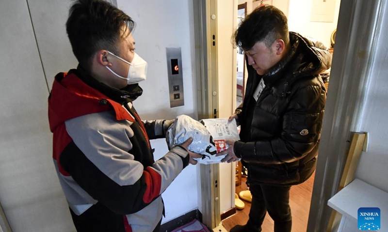 Delivery man Jiang Shuangjian delivers the first package on the first working day after the Spring Festival holiday in Chaoyang District of Beijing, capital of China, Jan. 28, 2023. Saturday marked the first day of work after the Spring Festival holiday in China.(Photo: Xinhua)