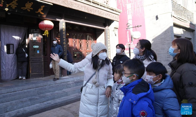 Tour guide He Jing (1st L) introduces scenic spots to tourists on the first working day after the Spring Festival holiday in Dongcheng District of Beijing, capital of China, Jan. 28, 2023. Saturday marked the first day of work after the Spring Festival holiday in China.(Photo: Xinhua)