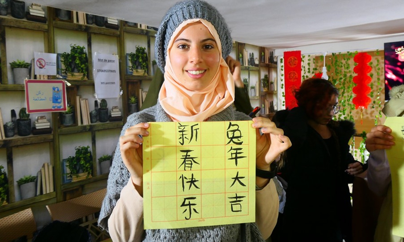 A Tunisian student shows the Chinese characters written by herself in the Oriental Knowledge Bookstore in Tunis, Tunisia on Jan. 27, 2023.(Photo: Xinhua)