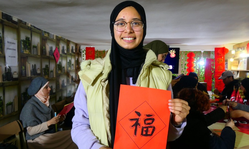 A Tunisian student shows the Chinese characters written by herself in the Oriental Knowledge Bookstore in Tunis, Tunisia on Jan. 27, 2023.(Photo: Xinhua)