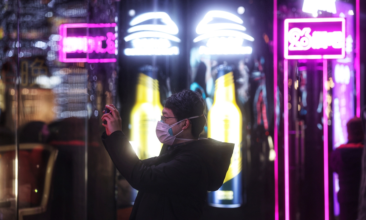 Residents in Beijing take photos of some of the city's oldest bars on a bar street located at the famous shopping complex Sanlitun, which are about to shut down for renovation as the buildings were deemed unsafe. Photo: Cui Meng/Global Times 