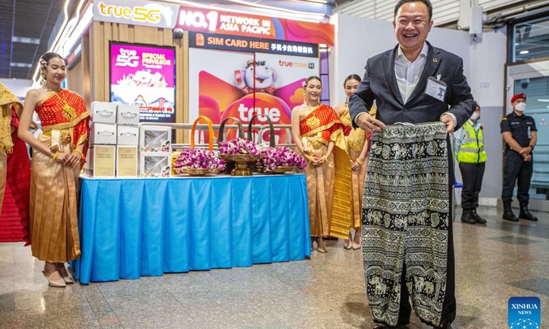 Yuthasak Supasorn, governor of the Tourism Authority of Thailand (TAT), shows a gift for Chinese tourists at Don Mueang International Airport in Bangkok, Thailand, Feb. 6, 2023.(Photo: Xinhua)