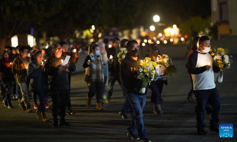 People hold candles and flowers to mourn the victims of the shootings in Half Moon Bay in California, the United States, Jan. 31, 2023. People here on Tuesday evening attended the memorial service and candlelight procession held in Half Moon Bay to mourn the victims of the mass shootings in the city.(Photo: Xinhua)