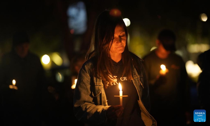 A woman holds a candle to mourn the victims of the shootings in Half Moon Bay in California, the United States, Jan. 31, 2023. People here on Tuesday evening attended the memorial service and candlelight procession held in Half Moon Bay to mourn the victims of the mass shootings in the city.(Photo: Xinhua)